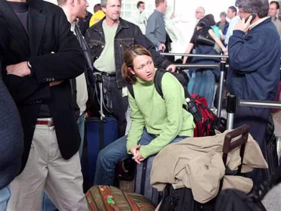 Katie Elmen of Chicago sits on her luggage as she waits in line to get to a ticket counter at Denver International Airport in this file photo. Elmen and other passengers spent close to four hours in ticket lines as a result of the cancellation of flights because of a blizzard. Such situations can be the cause of air rage incidents among passengers and also airline employees.